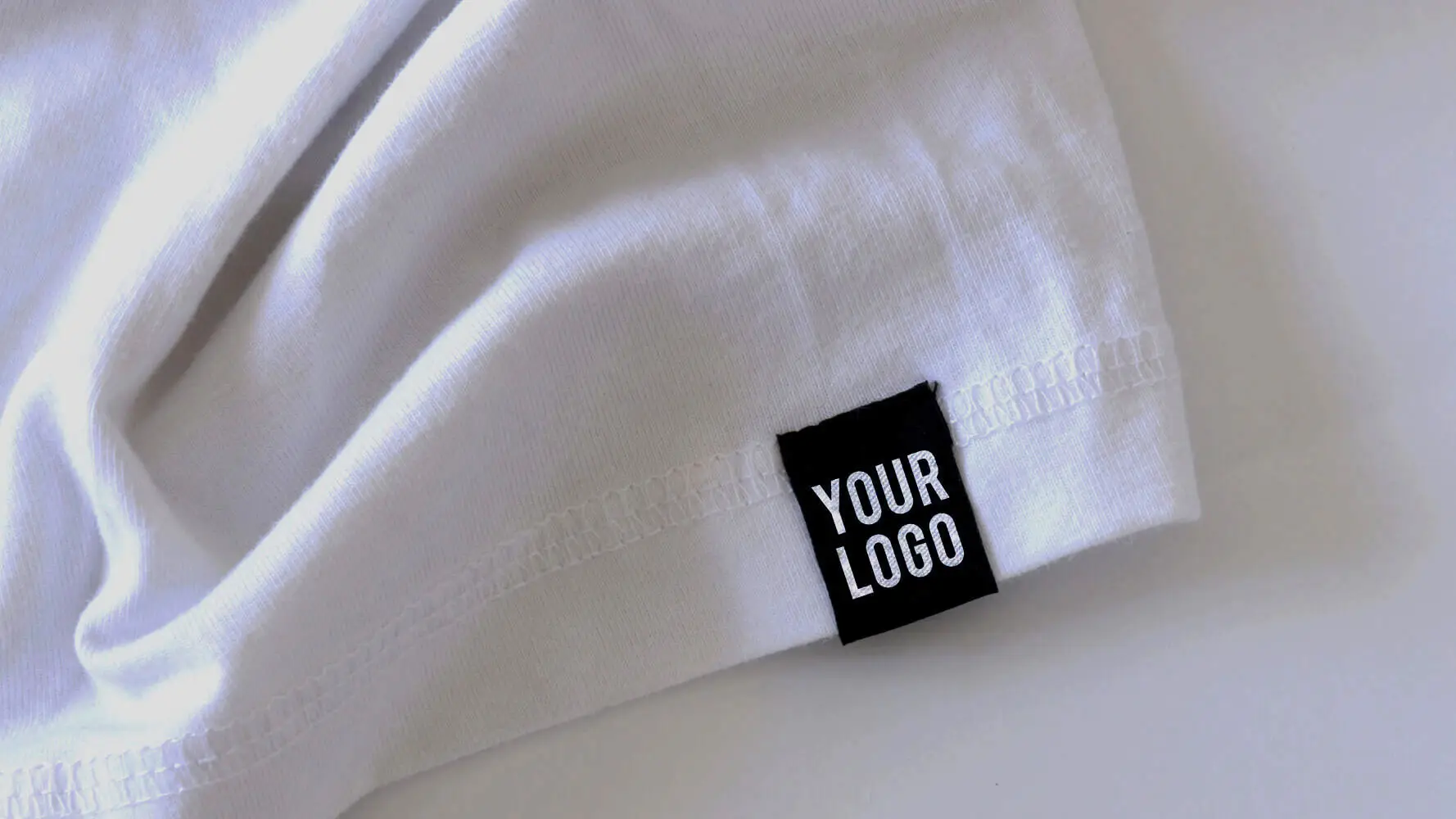 Custom black woven label stitched to a white garment