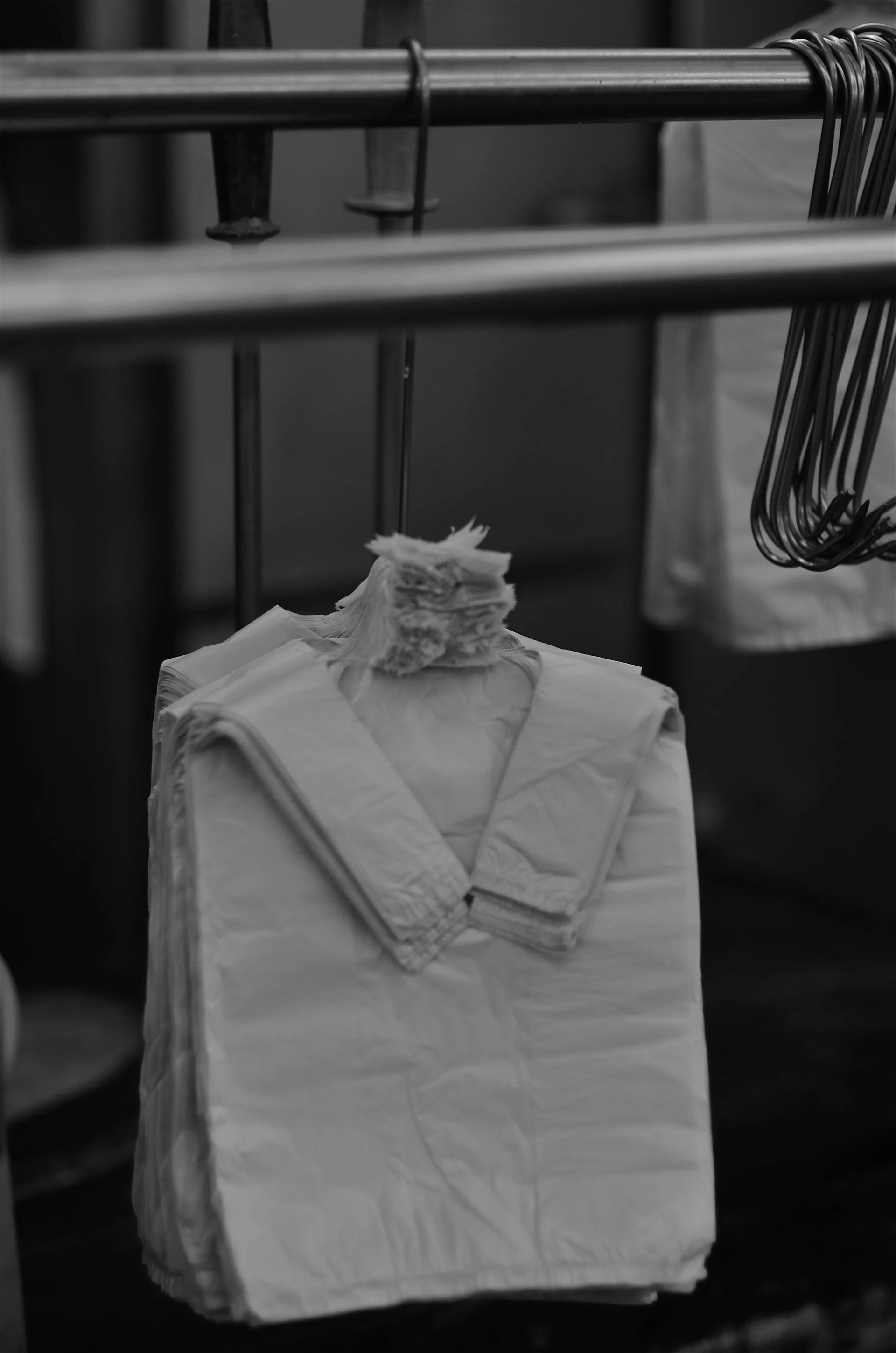 Folded white garments hanging on a rail in the finishing area